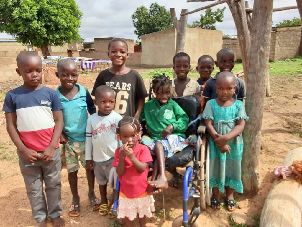 Photo d'un enfant en fauteuil roulant entouré par un groupe d'enfant