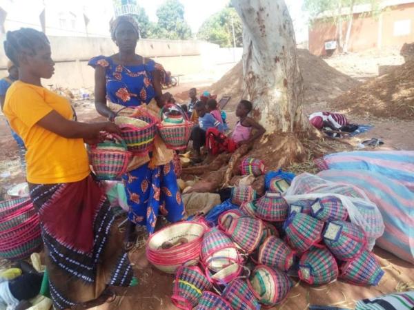 une femme sur le lieu d'exposition de sa marchandise, la vannerie