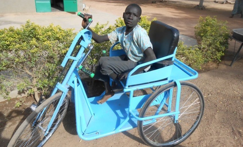 un enfant handicapé dans son tricycle