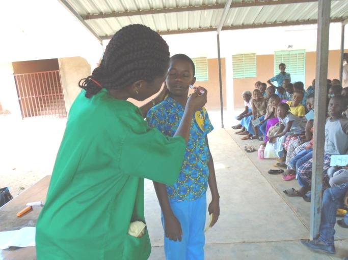 soins des yeux d'un enfant lors d'une campagne de dépistage