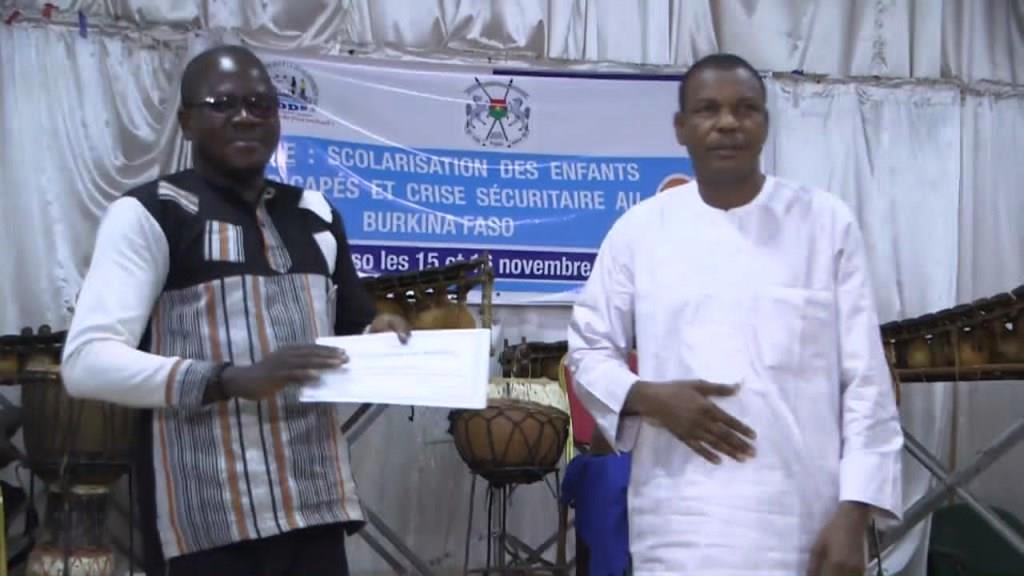 Remise d'une attestation de mérite au représantant d'une école
                                                                                                    à la cérémonie de proclamation des résultats
                                                                                                     du concours de l'école la plus inclusive de la ville de Bobo Dioulasso
                                                                                                     première édition