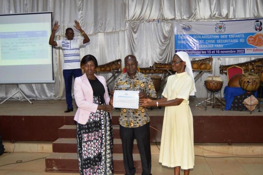 Remise au lauréat du concours de l'école
                                                                                                     la plus inclusive de la ville de Bobo Dioulasso première édition son attestion de mérite
                                                                                                      à la cérémonie de proclamation des résultats
                                                                                                      du concours de l'école la plus inclusive de la ville de Bobo Dioulasso
                                                                                                      première édition