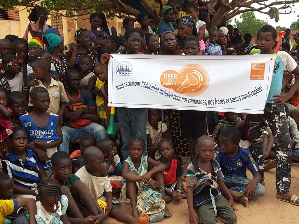  élèves portant une banderole avec un slogan en faveur
                                                                                                 de l'éducation inclusive lors de la sonnette d'alarme