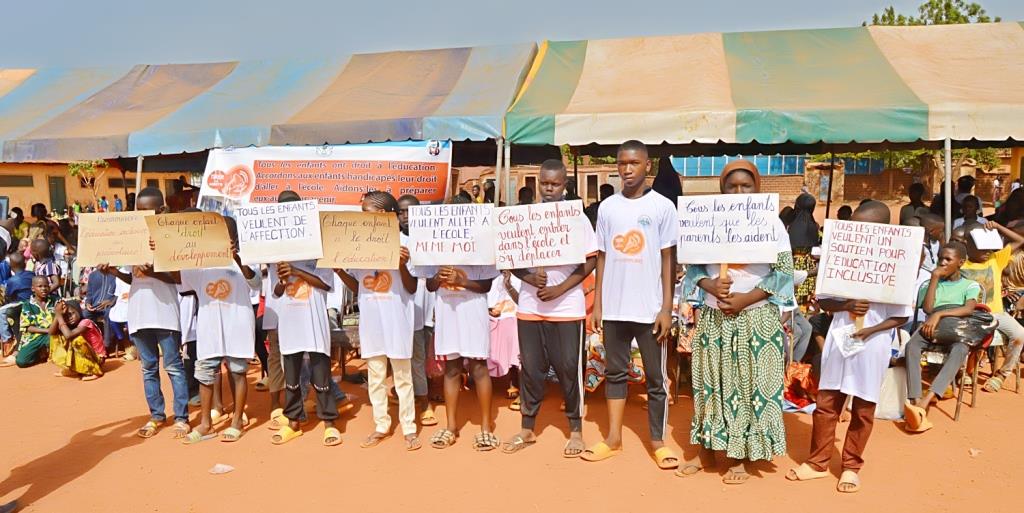 élèves portant des pancartes avec les slogans en faveur de l'éducation
                                                                                              inclusive lors de la sonnette d'alarme 