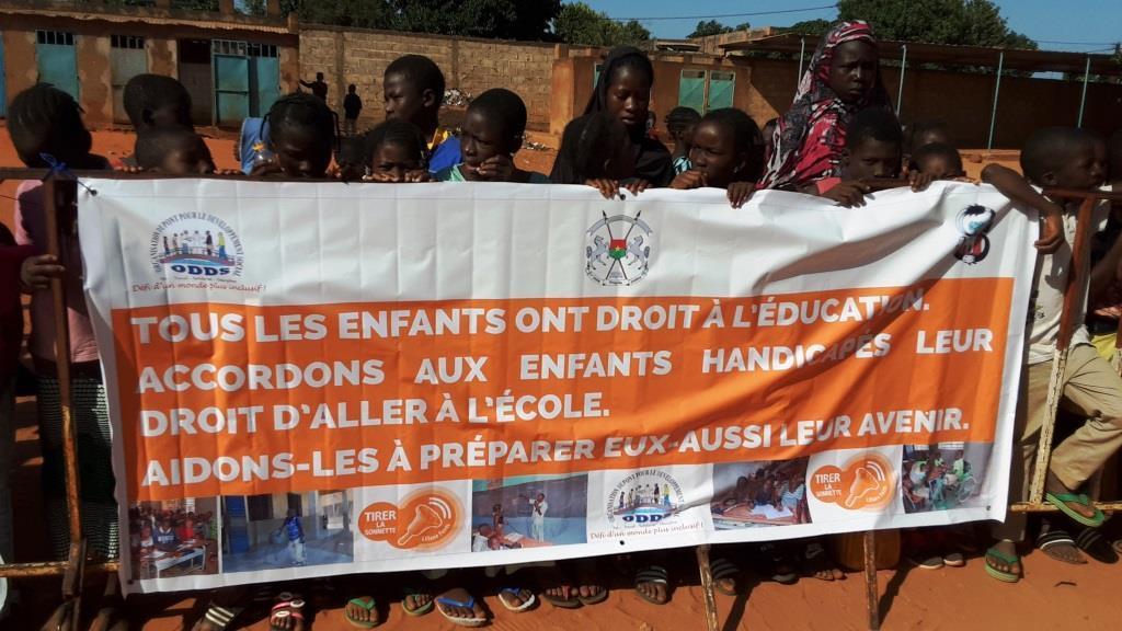 élèves portant une banderole avec les slogans en faveur
                                                                                              de l'éducation inclusive lors de la sonnette d'alarme